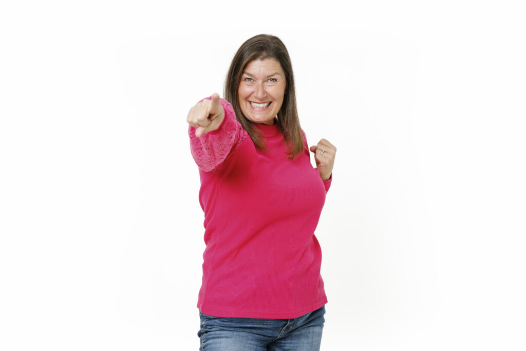 Mindy Jensen smiling and pointing toward the camera in an official BiggerPockets Money portrait.