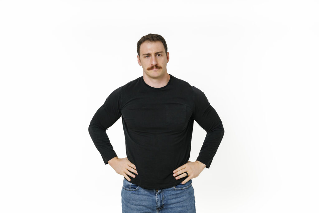Scott Trench standing in a black shirt in an official BiggerPockets Money portrait.